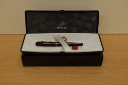 A boxed Parker Sonnet Premiere converter fill fountain pen in Laque red with gold trim having Parker