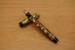 A Parker Duofold Streamline button fill fountain pen in green and pearl with three gold bands to the