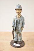 A studio pottery figure of a farmer with shotgun, mottled glaze to garments, standing at 23cm,