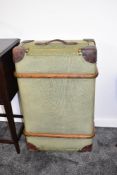 A large vintage green ribbed travel trunk with leather handles and padded corners, previous owners