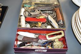 An interesting collection of militarian pocket knives, horsemans, fruit, pin badges, bottle