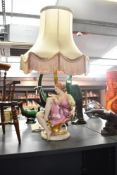 A 19th century style figural table lamp formed as a seated young woman, in period costume with guilt