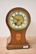 An Edwardian balloon shaped mantel clock, the oak and satinwood inlaid case enclosing an enamelled