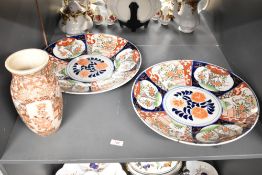 An attractive large pair of Japanese Imari chargers, hand decorated with foliage in blue, green