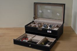 A Songmics watch display and storage box, having two layers and containing three wristwatches