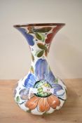 A vintage Spanish Pottery and Roma vase, decorated with colourful foliage on a white ground,