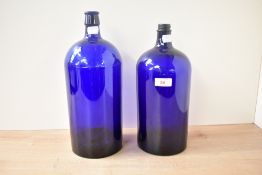Two early 20th century Bristol blue glass chemist bottles, largest h52cm