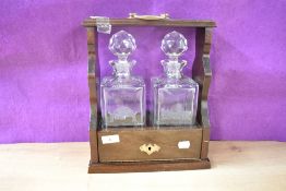 A quality 20th century mahogany two-bottle Tantalus with etching 'Underlay Garden School' and '