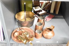 A collection of brass and copper utensils, to include a set of three graduating cider measures