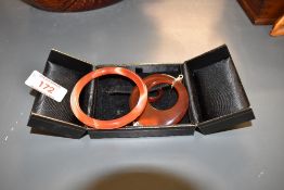 A small orange agate bangle, internal diamater approx 55mm, a matching band ring, size J and a