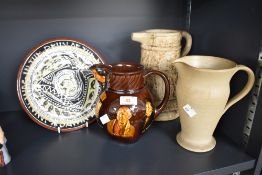 A Royal Doulton Kingsware pitcher decorated depicting various figures on a brown glaze ground,
