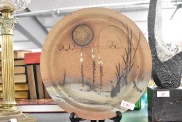 A 20th Century studio pottery plate of Paul Gooderham style, decorated with a stylised landscape
