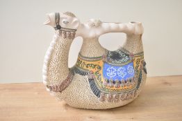 A vintage middle eastern water jug in the form of a camel, having stamp to base and measuring 23cm