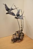 A large Gordon H Griffiths patinated metal study depicting swallows in flight above brambles,