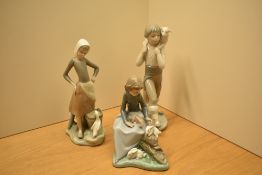 A Lladro porcelain figurine 'Girl with Milk Pail' number 4682 sold together with two Nao by Lladro