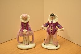 Two vintage porcelain clown figures, one depicted to be turning his pockets inside out. Bases