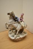 A vintage porcelain figure group depicting lady and gent on horseback, having markings to