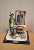 An Italian hand-painted ceramic figure depicting a youthful artist in a studio setting, measures