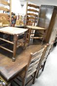 A traditional oak refectory style dining table and set of four ladderback chairs having rush seats