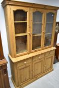 A modern pine bookcase with triple cupboard under, width approx. 136cm