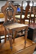 A 19th Century mahogany hall chair having open decoration to back
