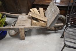 A vintage wooden garden barrow and selection of carved panels
