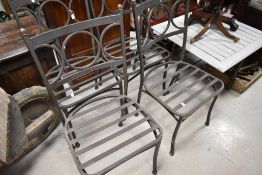 A set of four modern metal garden chairs and a similar low table