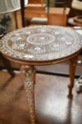 An Asian circular occasional table having bone inlay decoration , the triple legs having elephant