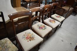 A set of four 19th Century Regency design rail back dining chairs having later woolwork seats