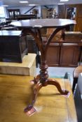 A Victorian mahogany occasional table having shaped top with splay support and turned column, on