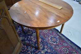 A vintage teak dining table of circular form diameter approx. 116cm, with additional extending