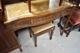 A reproduction Regency style side table or desk, having serpentine front, and a similar stool