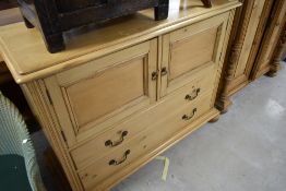 A Victorian pine laundry chest having cupboard section over two long drawers, width 122cm