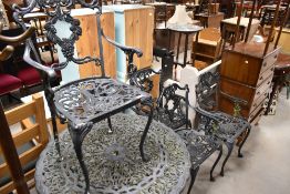 A traditional cast aluminium garden table and five similar armchairs