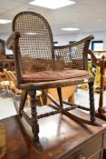 A late 19th or early 20th Century stained frame rocking chair having bobbin turned frame with