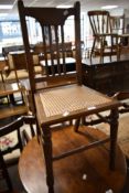 A late Victorian mahogany rail back bedroom chair having bergere cane seat