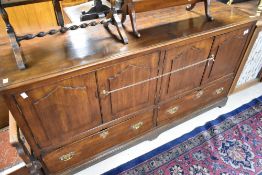 A Period oak sideboard base of kist design having panelled doors with two drawers to base, width