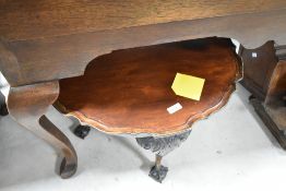 An early 20th Century coffee table having scallop edge on ball and claw feet