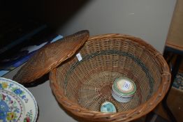 A vintage sewing basket containing a Ridgeway pot and a miniature brass picture frame.