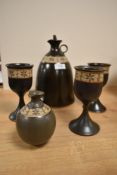 A studio pottery stoneware decanter, jug and three goblets, each with a stencilled and unglazed band