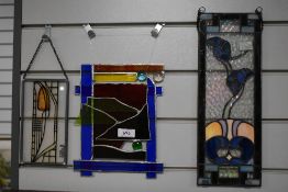 Two stained glass suncatchers and another similar.