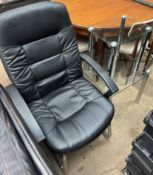 A black leatherette office chair together with a nest of two glass tables