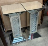 A pair of mirrored pedestals with square top and column on a spreading foot