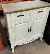 A cream painted side cabinet with a stripped top above two drawers and two cupboards on shaped legs