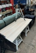 An IKEA trestle table together with a leather arm chair and a Manfrotto professional camera tripod