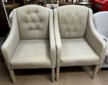 A pair of upholstered elbow chairs with button back upholstery on square tapering legs