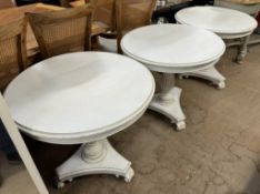 A set of three cream painted occasional tables on ribbed columns and a trefoil base and leaf carved