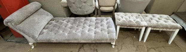 An upholstered day bed with a shaped back and button back upholstery on cabriole legs together with