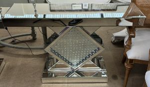 A mirrored side table with a rectangular top above a square base and crystal on a rectangular base