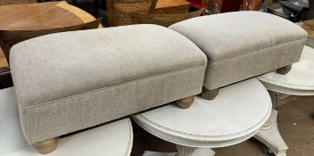 A pair of upholstered footstools on turned legs
